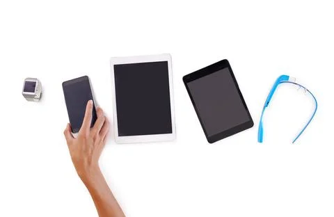 Tools of the trade. a hand holding a mobile phone as part of a technological set Stock Photos