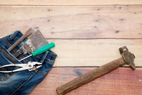 Tools for work and construction in the pocket of blue jeans on a wooden Stock Photos