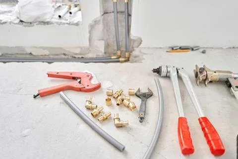 Tools for Work As A Plumber. Connection heating pipes to white Radiator in a new Stock Photos