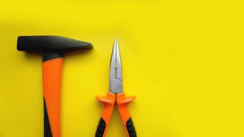 Tools worker, hammer, pliers on bright yellow background, top view Stock Photos