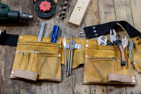 Tools in the workshop. Tools, hammer, drill, drill on a wooden table. Stock Photos