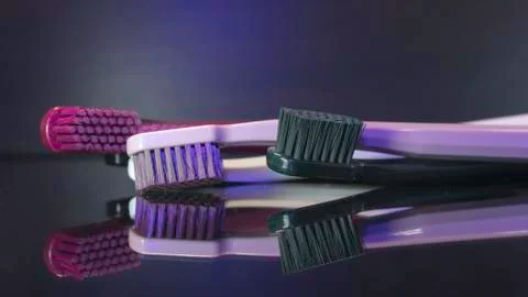 Tooth brushes close up isolated on the darck background. Stock Photos