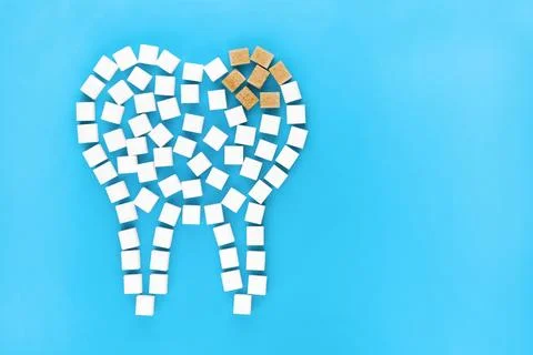 Tooth icon made of white cubes with golden crown on blue Stock Photos
