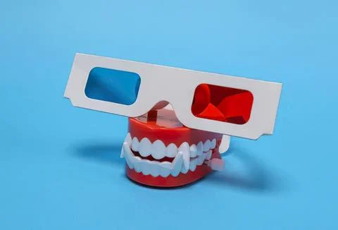 Tooth model with 3d glasses on blue background Stock Photos