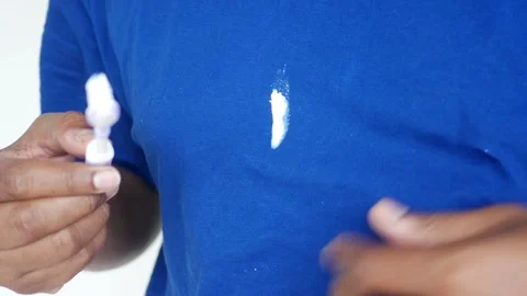 Tooth paste spilled on a shirt while holding a tooth brush Stock Footage 310979913
