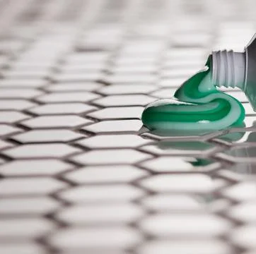 Tooth paste squeezing out onto bathroom floor Stock Photos