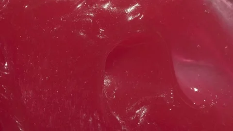 Tooth paste texture spreading by spatula footage. Red abstract wax cream Stock Footage 185460706