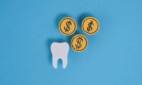 A tooth is surrounded by three dollar bills Foto stock