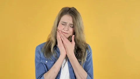 Toothache, Young Pretty Girl with Tooth Pain on Yellow Background Stock Footage 98674341