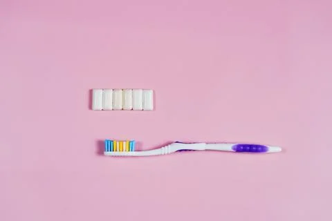 Toothbrush and gum on a pink background Stock Photos