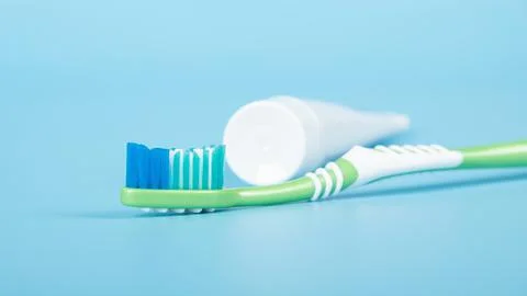 Toothbrush and toothpaste on a blue background close-up, dental care Stock Photos