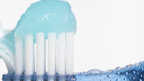 Toothbrush and toothpaste. On blue toothbrush squeezed slowly blue toothpaste on Video stock 159133698