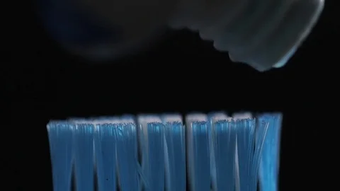 Toothbrush and toothpaste on blurred black background Stock Footage 73675492