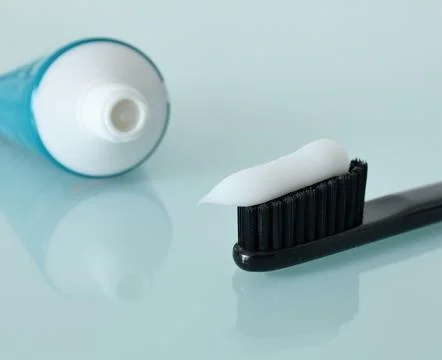 Toothbrush and toothpaste on a light blue background Stock Photos