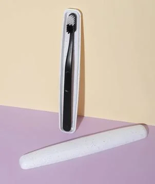 Toothbrush and toothpaste lying on pastel pink and yellow background Fotos Stock