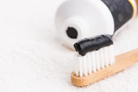 Toothbrush with black charcoal toothpaste Stock Photos