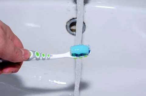 Toothbrush with Blue Gel Toothpaste Under Running Tap Water Oral Hygiene Co.. Stock Photos