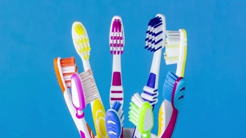 Toothbrush cup with toothbrushes in different colors, loop 스톡 동영상 92568990