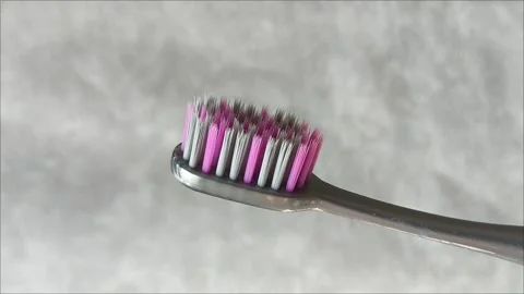 A toothbrush with fine bristles on a gray background in close up Stock Footage 313356000