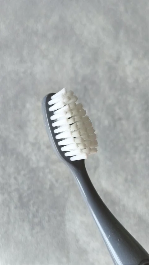 A toothbrush with fine bristles on a gray background in close up Stock Footage 313356100