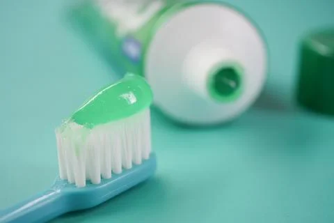 Toothbrush with green toothpaste on blue background Foto stock