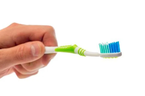 Toothbrush in hand on an isolated background Stock Photos