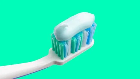 Toothbrush head with toothpaste on mint green background, close-up view, macr Foto stock