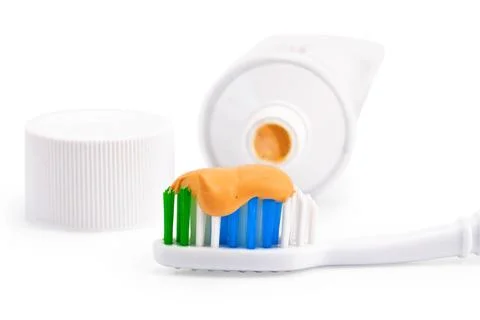 Toothbrush with orange toothpaste Toothbrush with orange toothpaste, a tub... 스톡 사진