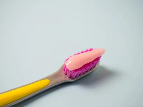 Toothbrush with pink toothpaste. Close up of pink toothpaste on a toothbrush. Stock Photos