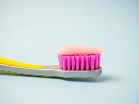 Toothbrush with pink toothpaste. Close up of pink toothpaste on a toothbrush. Stock Photos