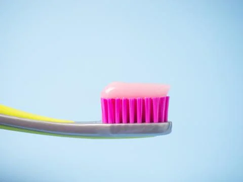Toothbrush with pink toothpaste. Close up of pink toothpaste on a toothbrush. Stock Photos