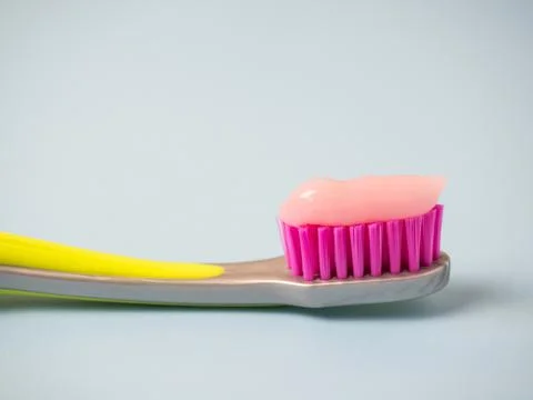Toothbrush with pink toothpaste. Close up of pink toothpaste on a toothbrush. Stock Photos