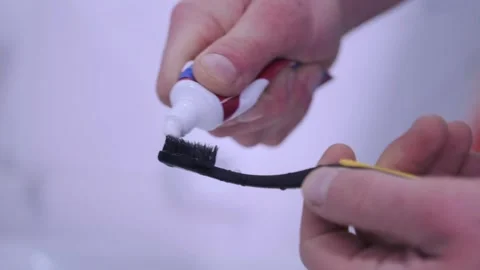 Toothbrush receiving white paste carefully, Gentle squeezing of small toothpaste 스톡 동영상 331281147