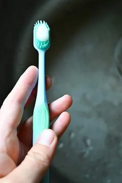 A toothbrush  in a small person's hand Stock Photos