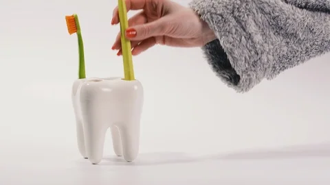 Toothbrush. Toothbrushes stand on a stand in the form of a large tooth. Stock Footage 126358348