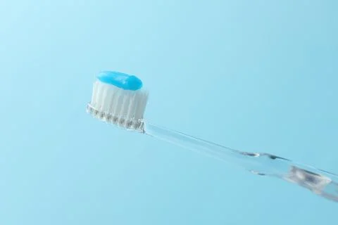 Toothbrush with toothpaste in air on light blue background, closeup Stock Photos