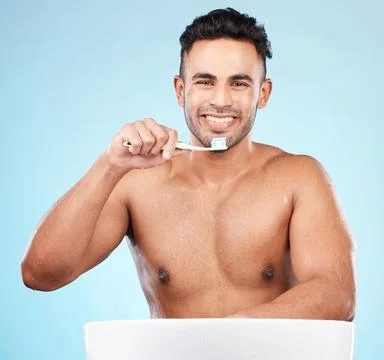 Toothbrush, toothpaste and indian man portrait brushing teeth in blue background Stock Photos