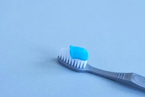 Toothbrush with toothpaste on blue background, close-up Stock Photos