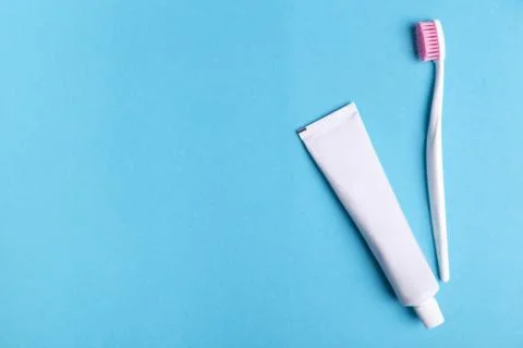 Toothbrush with toothpaste on blue background with copy space. Фото