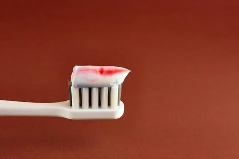 Toothbrush with toothpaste on a brown background. Dental care. Oral hygiene. Stock Photos