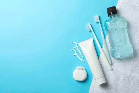 Toothbrush toothpaste floss and water bottle on blue background Foto stock