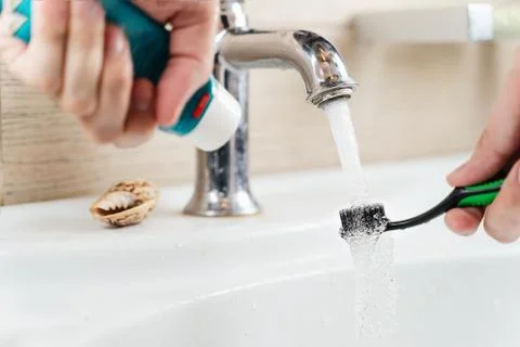 A toothbrush with toothpaste in the hand Stock Photos