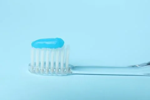 Toothbrush with toothpaste on light blue background, closeup Stock Photos