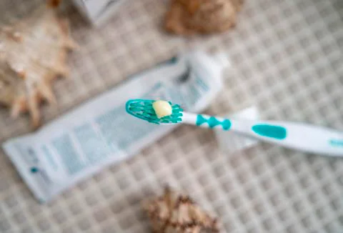 A toothbrush with toothpaste squeezed out on it against the background Stock Photos