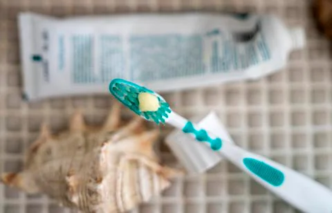 A toothbrush with toothpaste squeezed out on it against the background Stock Photos
