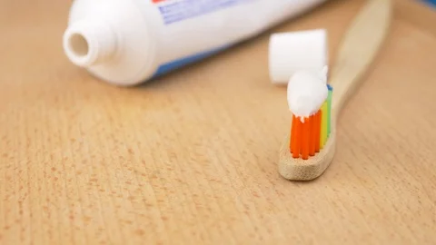 Toothbrush with toothpaste on a wooden background Stock Footage 100684067