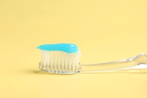 Toothbrush with toothpaste on yellow background, closeup Stock Photos
