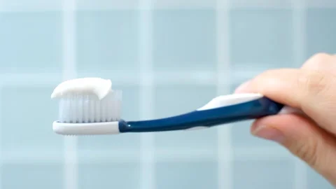 Toothbrush with white toothpaste close-up on blue tile background. Stock Footage 314472430