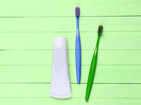 Toothbrushes and toothpaste on green background Fotos Stock