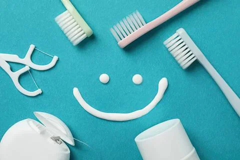 Toothbrushes and toothpaste with a smiley face on blue background Foto stock